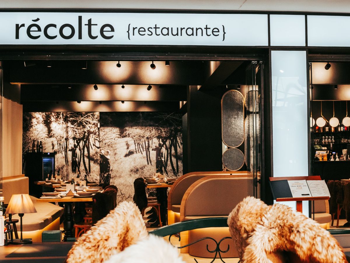 Fachada do Récolte na Rua Coberta, com o letreiro récolte {restaurante} e o salão iluminado